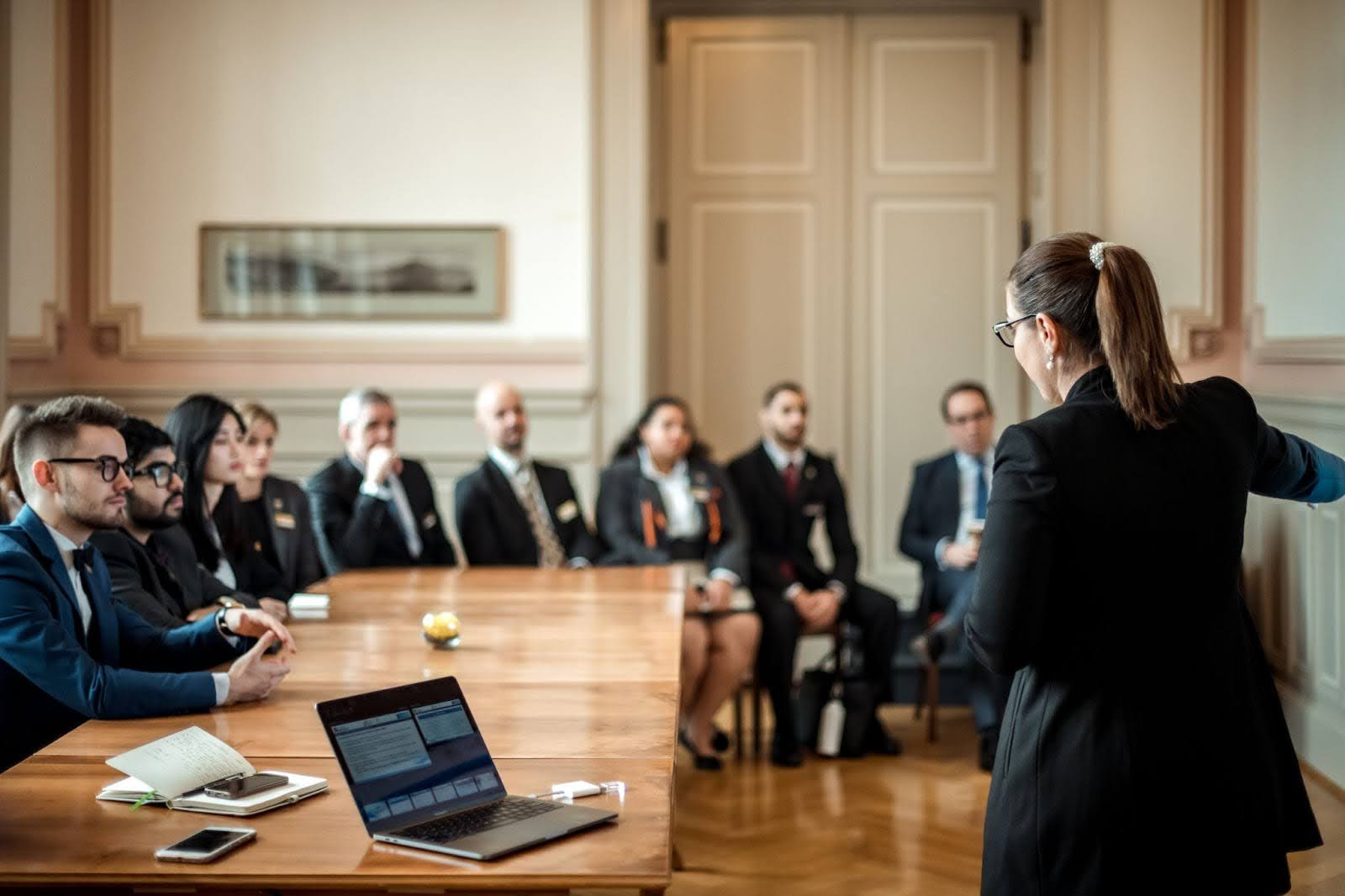 A group of people listening to a female manager talking.