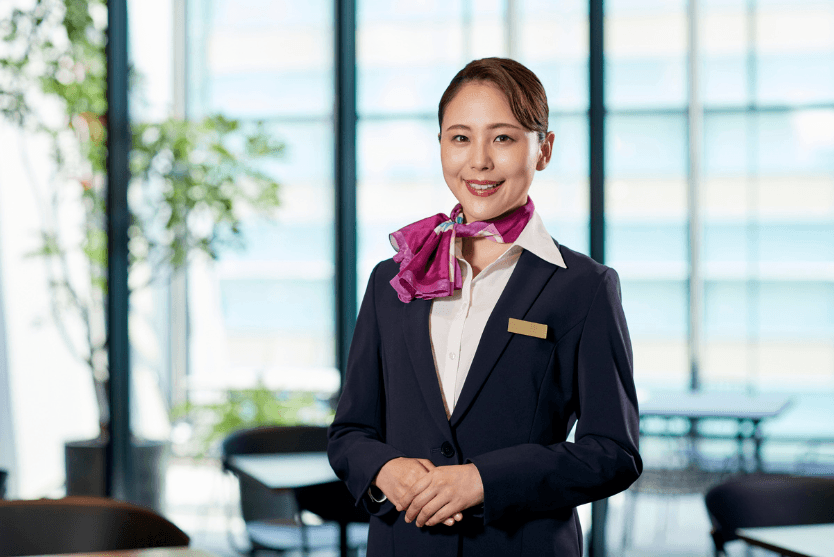 A concierge woman smiling at the camera.