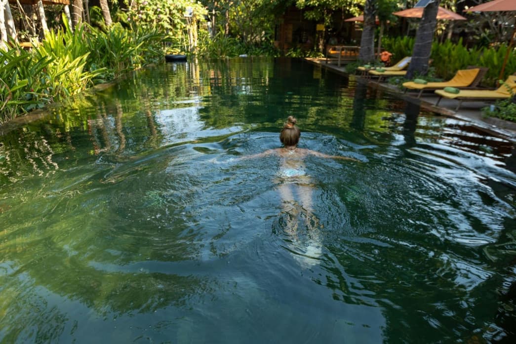 A woman swimming in the pool of a boutique hotel